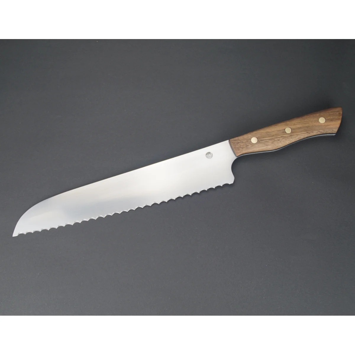 brotmesser-full-tang-kuem-nr25-1-02.webp Handgeschmidetes Brotmesser Nussbaumholz Griff Wellenschliff